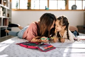 Mother and daughter coloring together.