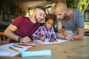 Two fathers with the daughter they are seeking to adopt with the guidance of an experienced adoption lawyer in Knoxville. 